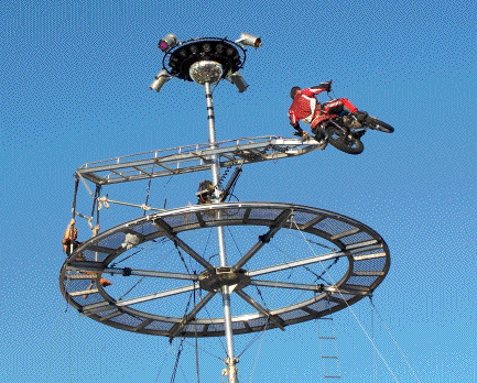 John's motorcycle becomes airborne as he begins to perform aerial flips.