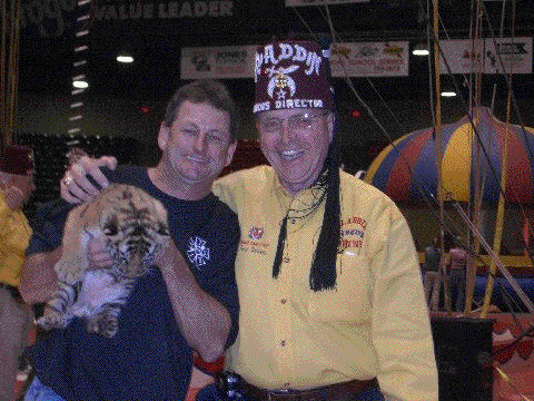 John holds a newborn tiger with the circus director of the Aladdin Shrine Circus