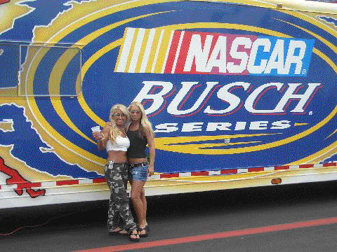 Tina and Ashley pose by the NASCAR Busch Series display at a NASCAR race performance