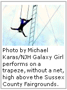 Galaxy Girl performs on a trapeze, without a net, high above the Sussex County Fairgrounds